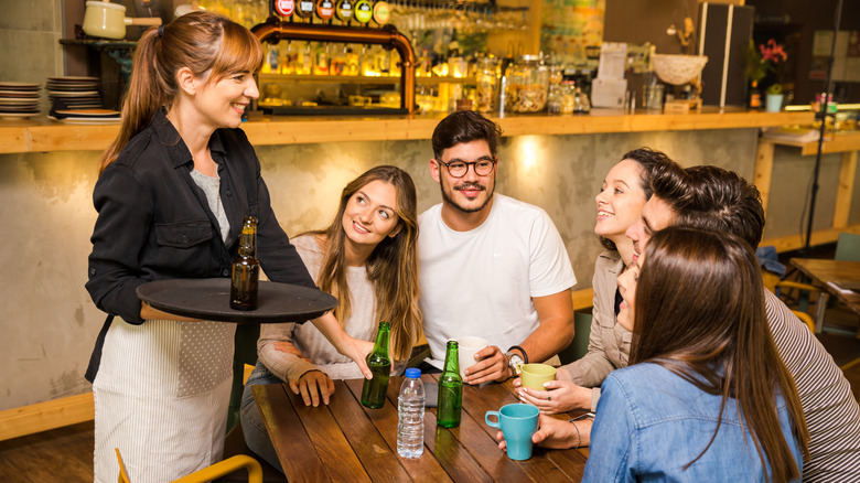 Group of customers looking up and smiling at server