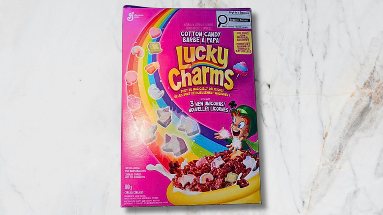 A box of Cotton Candy Lucky Charms cereal on marble background