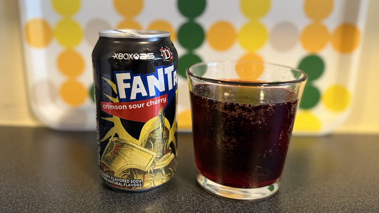 Can of Fanta Crimson Sour Cherry next to glass of it
