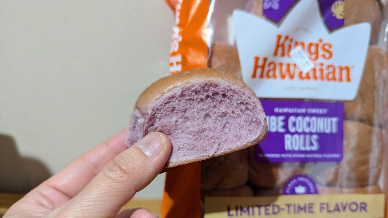 Hand holding ube coconut hawaiian roll