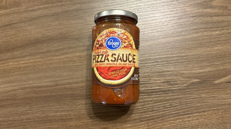 Jar of Kroger Parlor Style Pizza Sauce laying on wooden surface