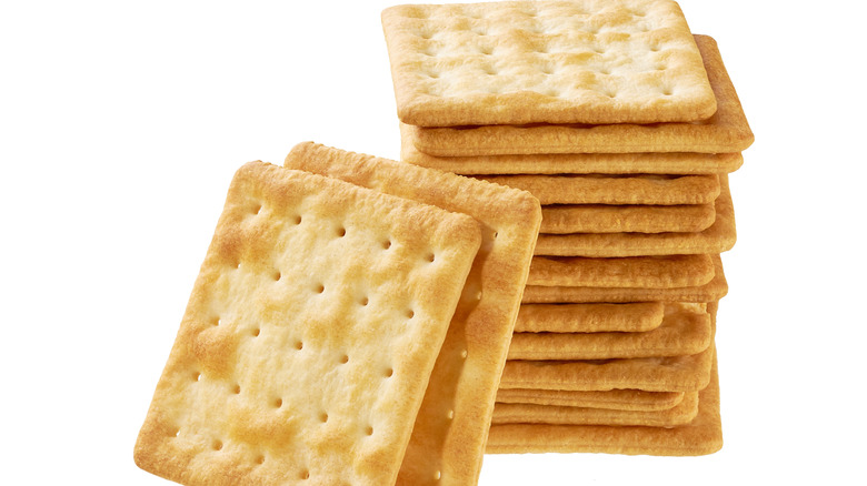 A stack of saltine crackers on a white background