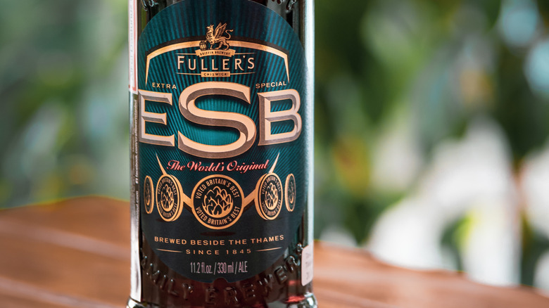 A closeup of a bottle of Fuller's ESB on a table outside