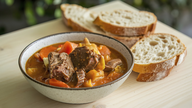 Beef stew in a bowl with crusty bread