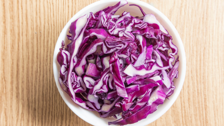 Shredded red cabbage in a white bowl