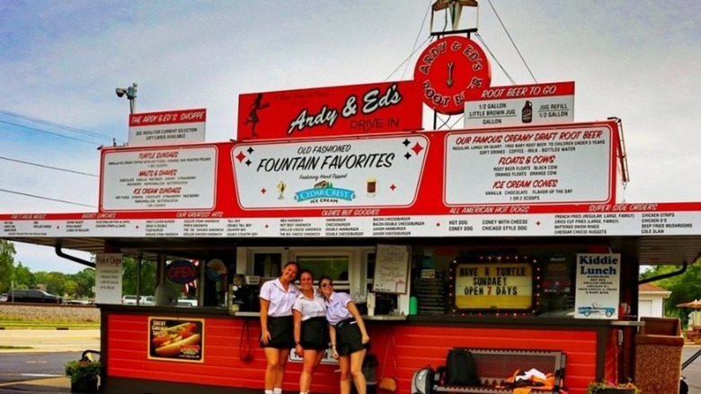 Exterior of Ardy & Ed's with three women carhops smiling at camera