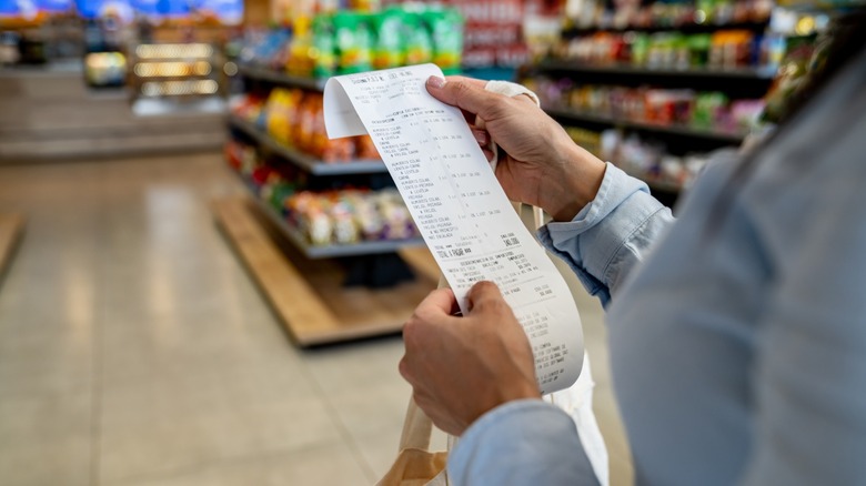 Woman looking at her receipt in a grocery store