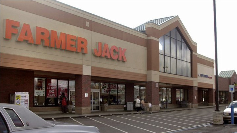 Farmer Jack logo on large grocery store storefront near parking lot in strip mall