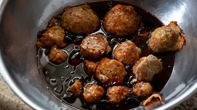 A metal bowl of grape jelly meatballs
