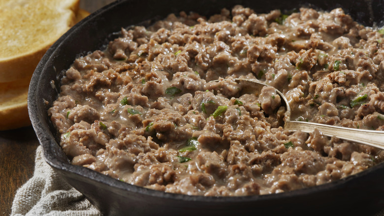 Ground beef cooking in a pan with gravy