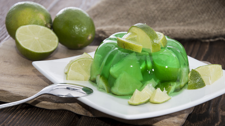 Lime Jell-O salad on a white plate with lime pieces