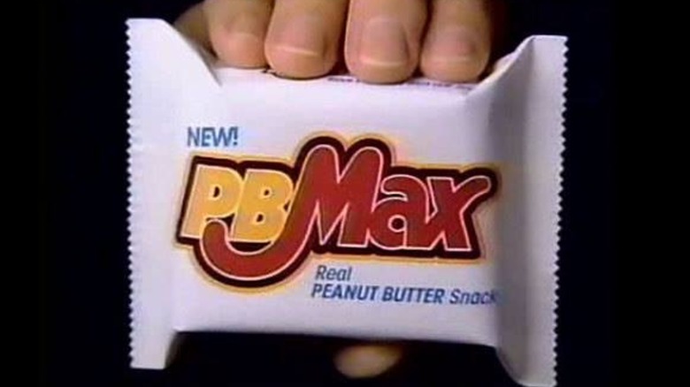 PB Max bar held by a hand up close to camera lens