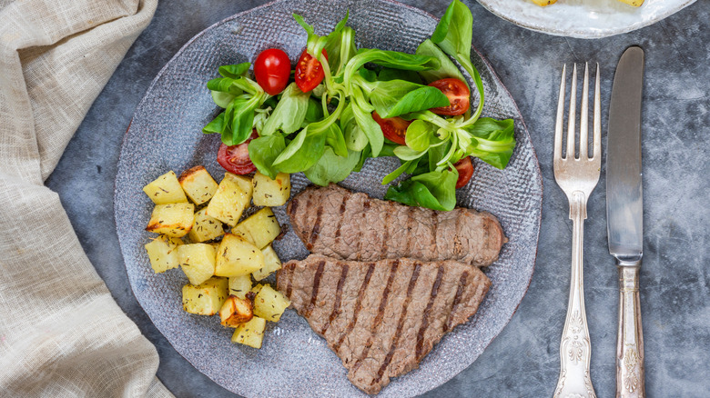 Minute steak on a plate with potatoes and salad