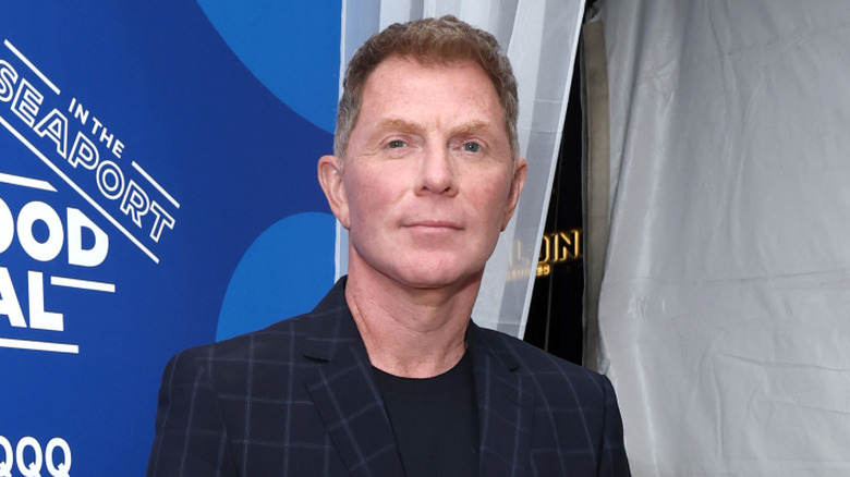 Bobby Flay wearing a suit and softly smiling