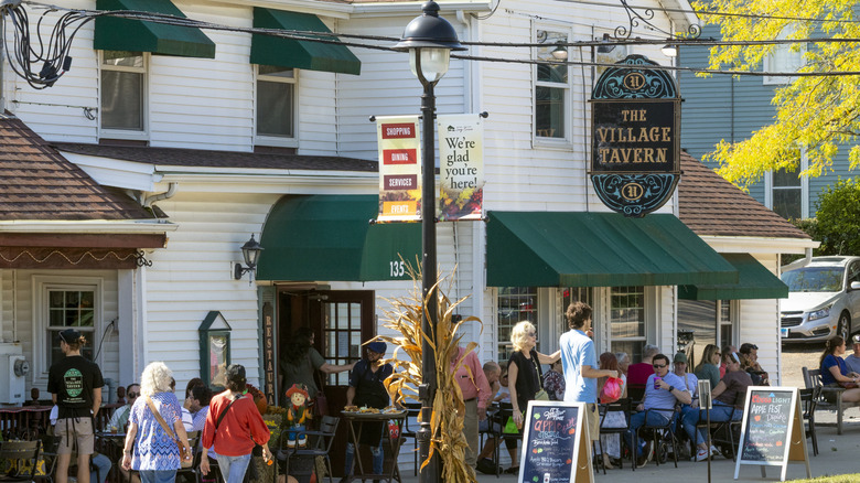 The exterior of The Village Tavern in Long Grove, Illinois with several patrons sitting outside