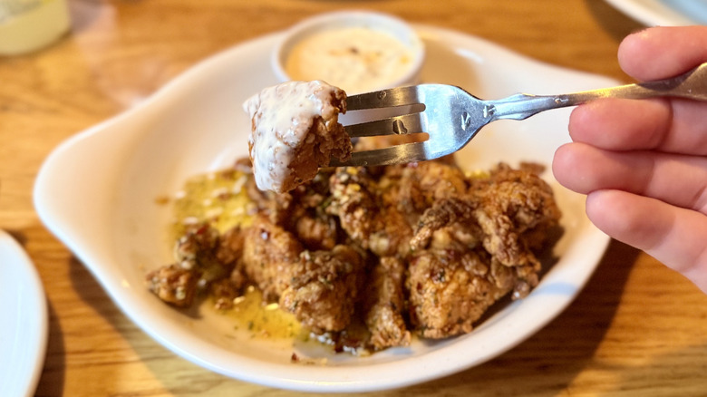 Holding a chicken bite on a fork