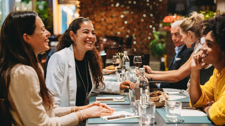 Multiple smiling women seated at a restaurant table.