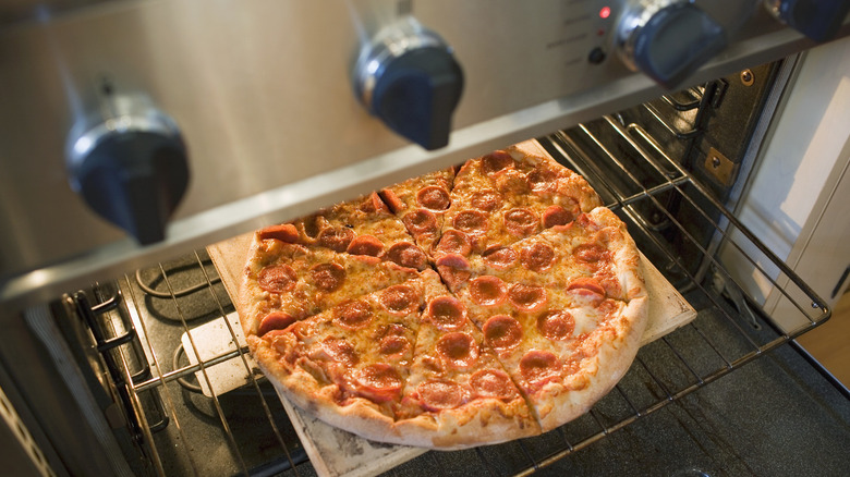 A frozen pepperoni pizza baked on an oven shelf