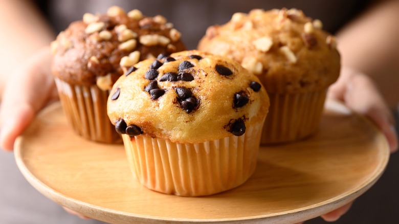 Person holding plate with three muffins