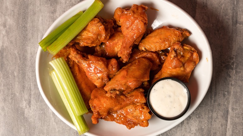 Plate of buffalo wings with celery and blue cheese dip