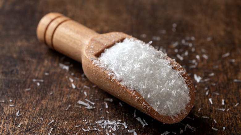 MSG white crystals in a wooden scoop