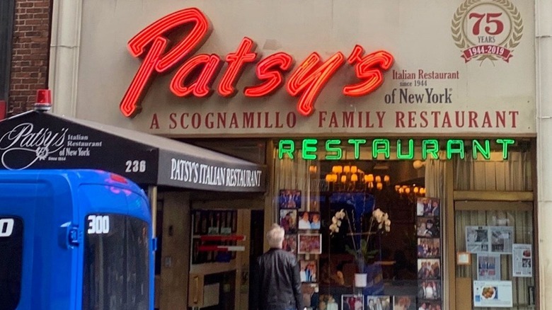 Front view of Patsy's Italian Restaurant in New York City with a man looking into the restaurant