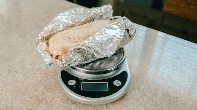 A burrito on a kitchen scale.
