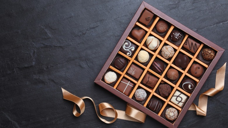 A box of chocolates with gold ribbon.