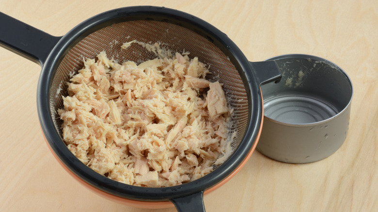 Tuna being drained with a fine mesh strainer