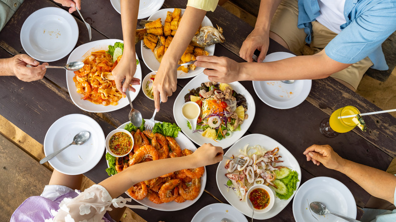 overhead shot of people eating a family-style meal at a seafood restaurant