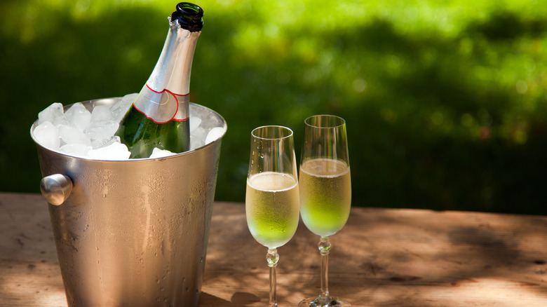 Champagne botte in ice bucket with 2 glasses of wine