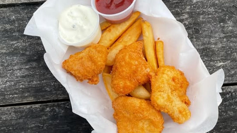 A serving of fish and chips sitting on a table.