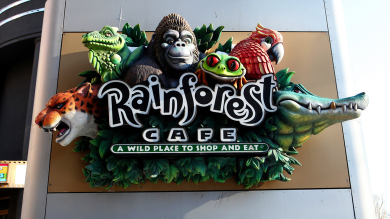 A Rainforest Cafe sign featuring wild animals outside the restaurant