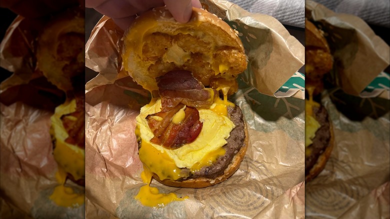 Unwrapped Burger King Bacon Cheddar Hash Whopper with top bun lifted off