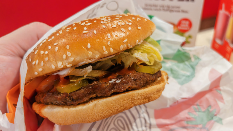 Closeup of hand holding Whopper burger at Burger King