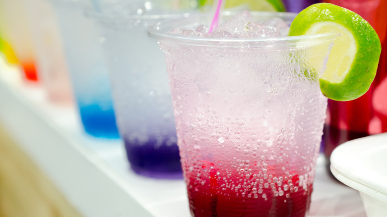 A row of Italian sodas in small plastic cups.