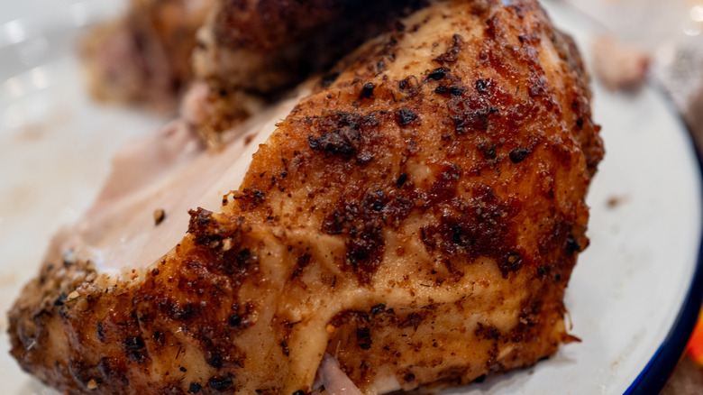 Well-seasoned roasted chicken from a restaurant on a white plate