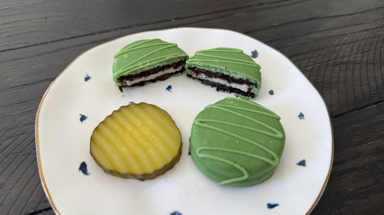 A white plate with Oreo Dill Pickle Flavored Fudge Cookies and a pickle slice