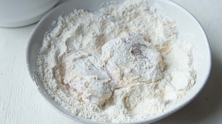 raw chicken and flour in a white bowl