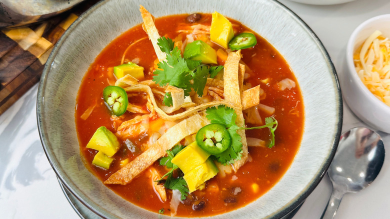 Bowl of chicken tortilla soup with toppings