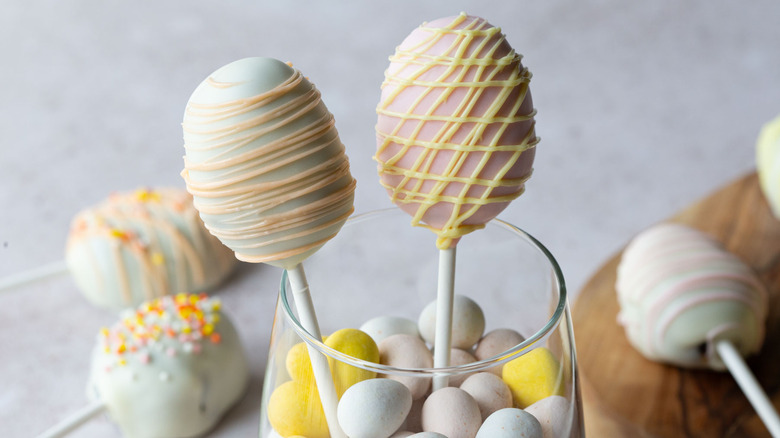 Easter egg cake pops standing in a glass of candy eggs