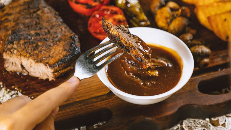 Dipping piece of steak in steak sauce