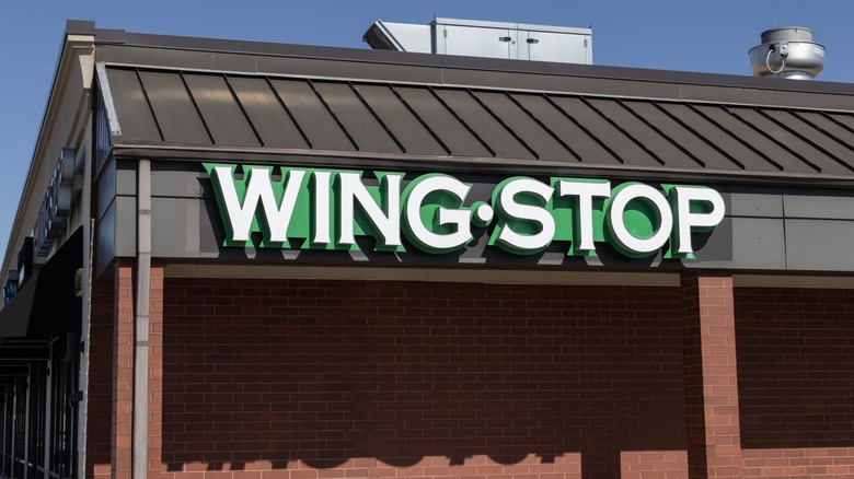The exterior of a brick Wingstop location with a black paneled roof