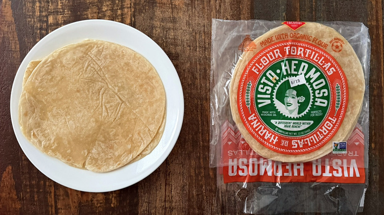 Vista Hermosa flour tortillas on a white plate and in a plastic package on a wooden table