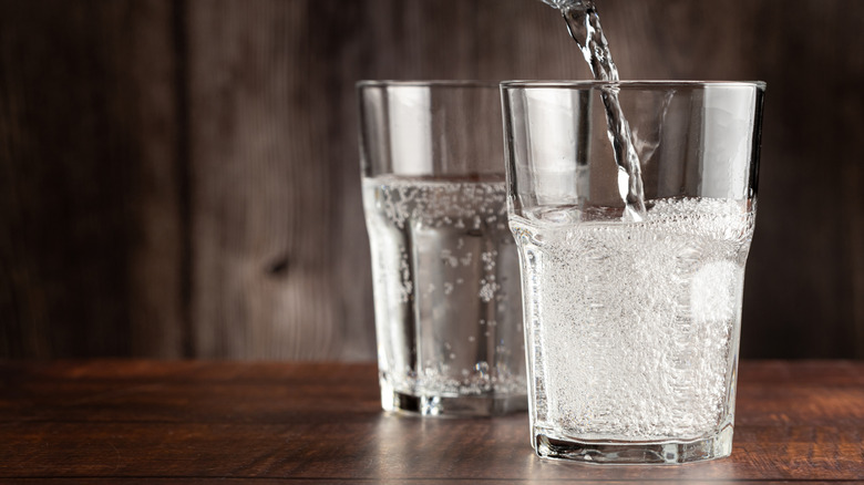 Sparkling water pouring into two glasses