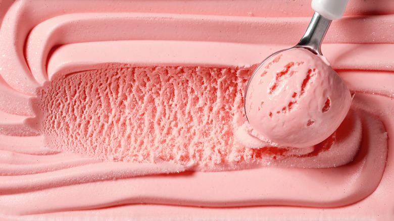 A strawberry ice cream being scooped