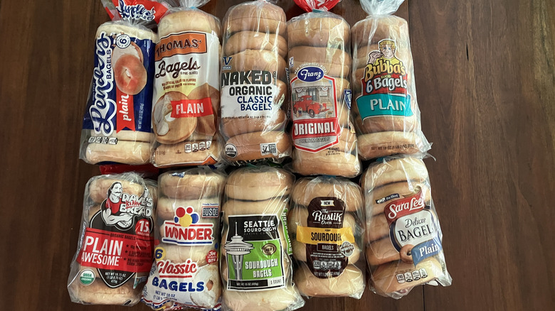 10 grocery store bagels in packaging on table surface.