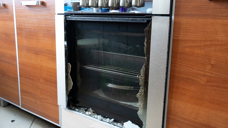 Broken oven door with glass on floor