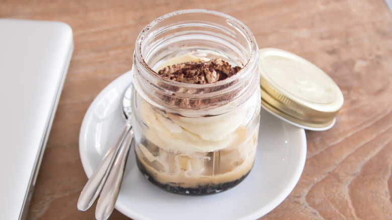 An individual Boston cream pie in a mason jar on a plate