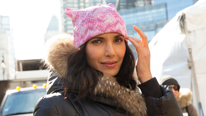 Padma Lakshmi outside in New York City wearing winter coat and pink beanie